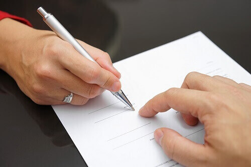 Person signing prenuptial agreement.